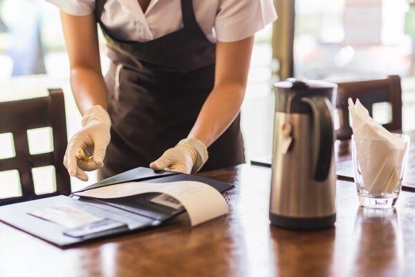 Photo of a server collecting the paid bill at the end of a meal.