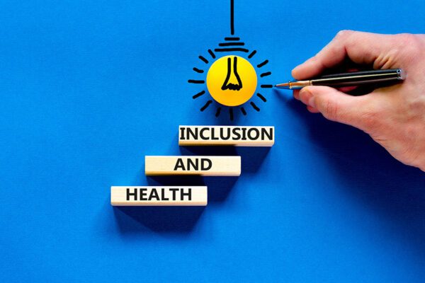 Health and inclusion symbol. Concept words Health and inclusion on wooden block. Beautiful blue table blue background. Doctor hand. Business motivational health and inclusion concept.