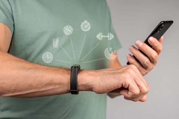 Hands with sport smartwatch and holding smartphone for sync.