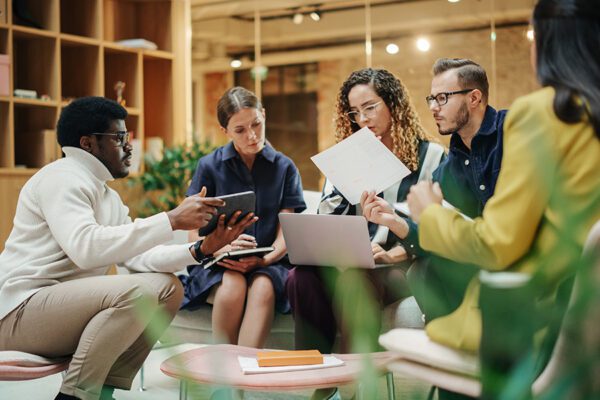 Female Manager Leading a Meeting About Sustainability and Ethnicity with her Multiethnic Teammates. Young Group of Employees Presenting Their Project Ideas To Startup CEO.