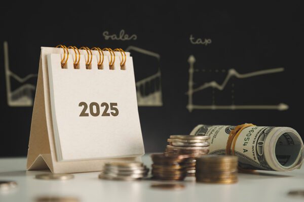 Finances and plans for 2025, with a 2025 calendar and coins on a table.